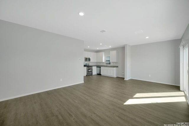 unfurnished living room featuring sink and dark hardwood / wood-style floors