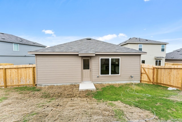 rear view of property featuring a lawn