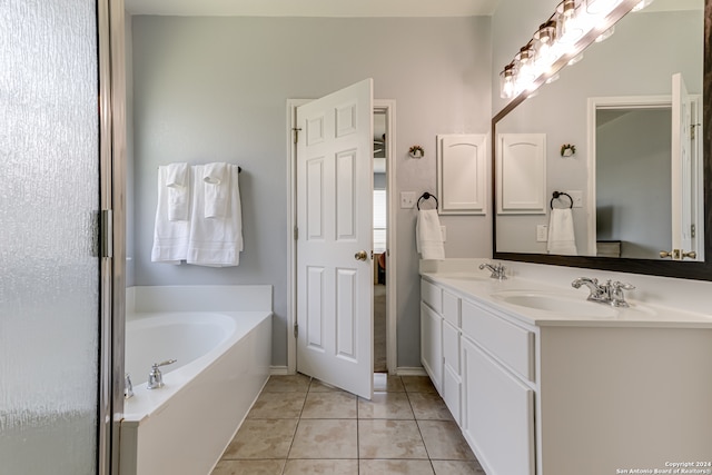 bathroom with dual bowl vanity, tile flooring, and a bath