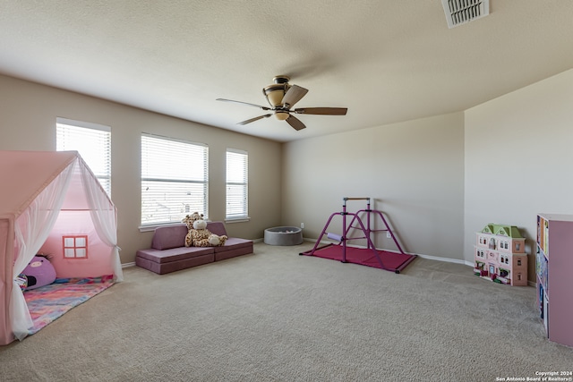 playroom with a wealth of natural light, carpet floors, and ceiling fan