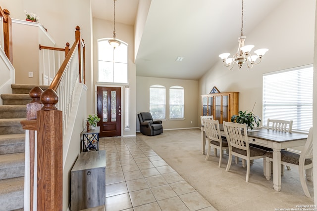 foyer entrance with high vaulted ceiling, an inviting chandelier, and light tile floors