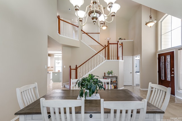 dining area featuring tile flooring, plenty of natural light, and a towering ceiling