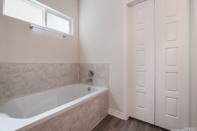 full bathroom featuring wood finished floors and a bath