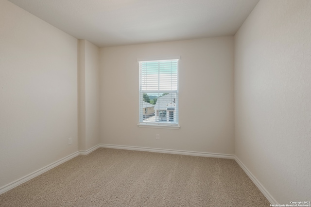 carpeted spare room featuring baseboards