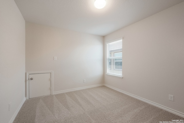 unfurnished room with carpet floors and baseboards