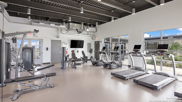 exercise room with a towering ceiling