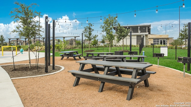 view of home's community with a lawn, fence, and playground community