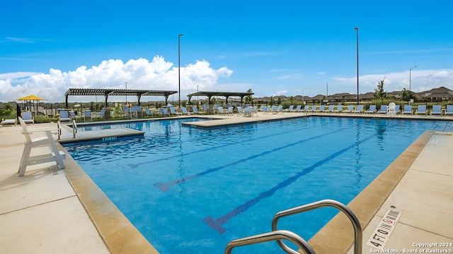 community pool with a patio area and a pergola