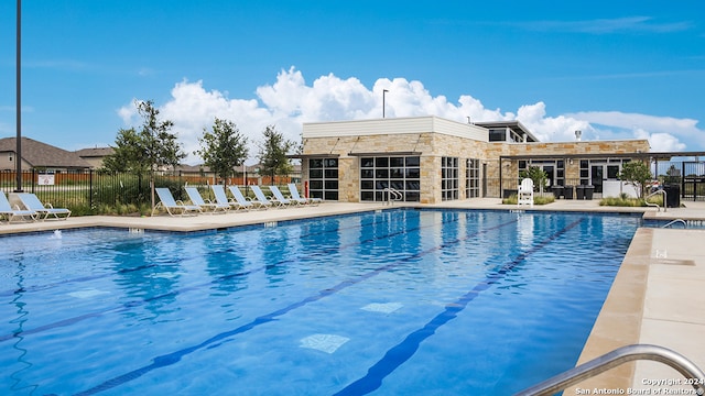 pool with a patio area and fence