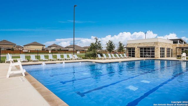 pool featuring fence and a patio