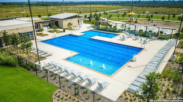 community pool featuring fence and a patio