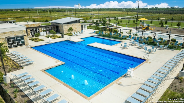 community pool with a patio and fence