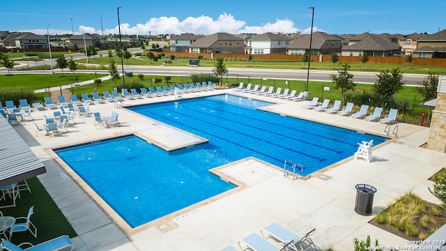 pool with a residential view, fence, and a patio