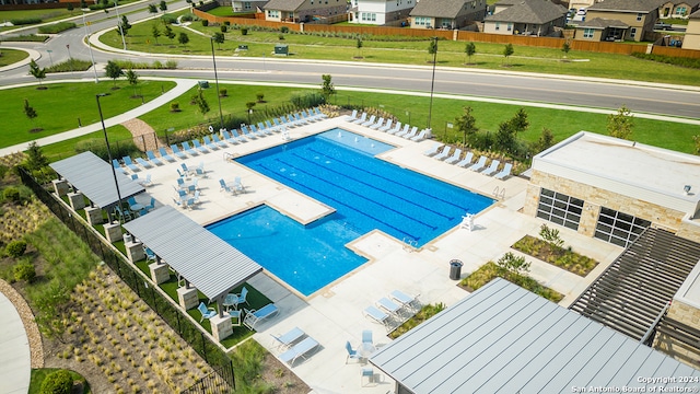 pool with a patio area, a residential view, and fence