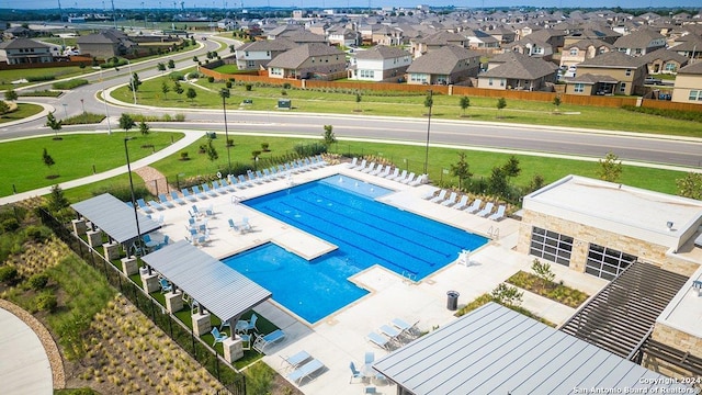 community pool with a residential view, fence, and a patio