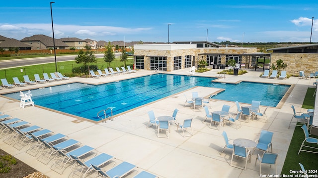 pool with a patio and fence