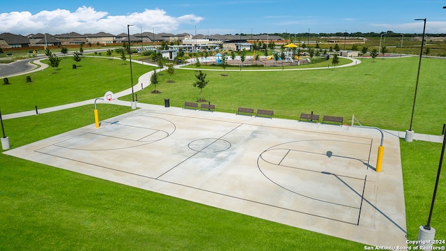 view of sport court featuring community basketball court, a residential view, and a lawn