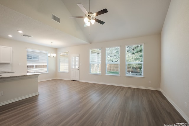 unfurnished living room featuring dark wood-style flooring, visible vents, baseboards, and ceiling fan with notable chandelier