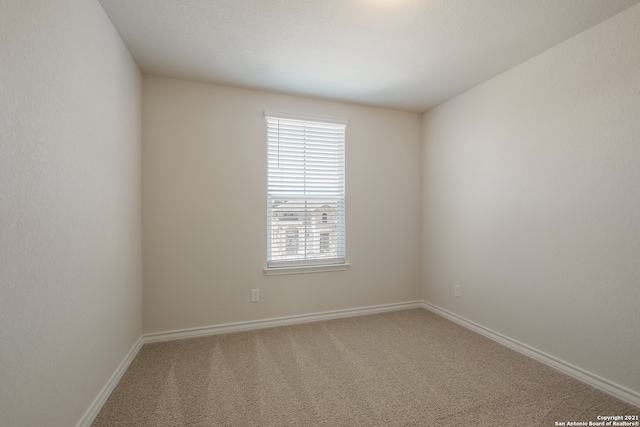 carpeted empty room with baseboards