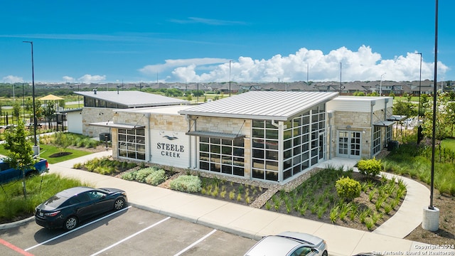 view of building exterior with uncovered parking and a residential view