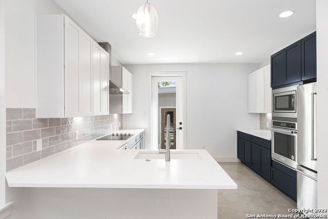 kitchen with stainless steel appliances, sink, tasteful backsplash, and kitchen peninsula