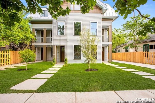 view of front of property featuring a front lawn and a balcony