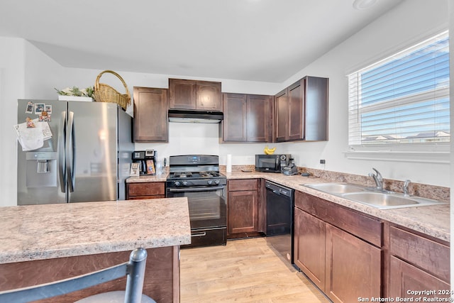 kitchen with dark brown cabinets, sink, light hardwood / wood-style floors, and black appliances