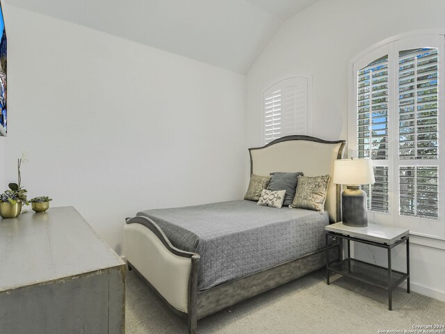 bedroom with carpet and vaulted ceiling