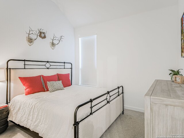 carpeted bedroom featuring vaulted ceiling