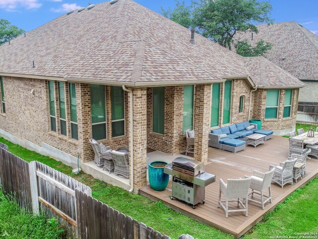 rear view of house with a deck and an outdoor living space