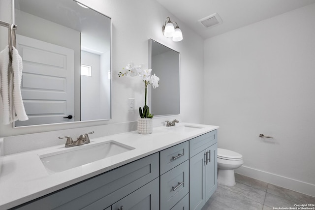 bathroom featuring dual vanity, tile floors, and toilet