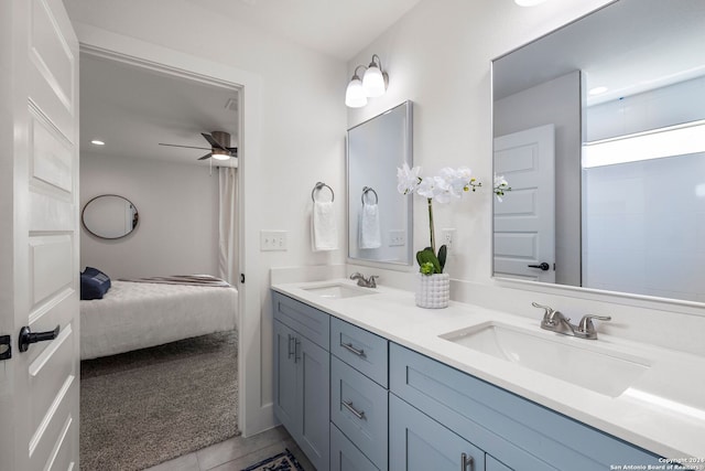 bathroom featuring tile floors, ceiling fan, vanity with extensive cabinet space, and double sink