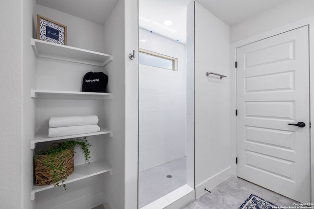 bathroom with a shower and tile flooring