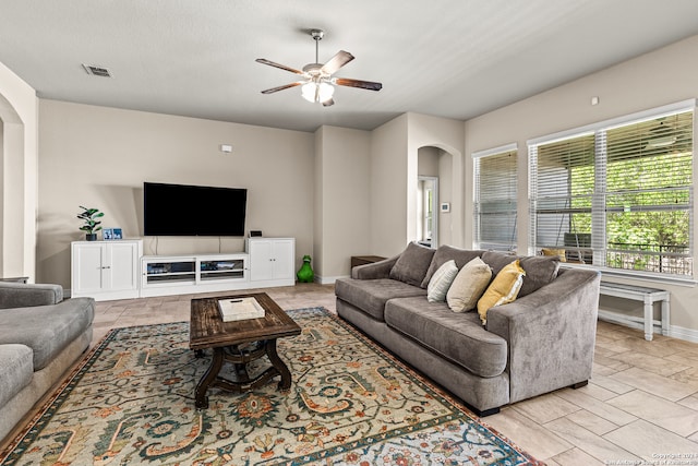 living room with a textured ceiling and ceiling fan