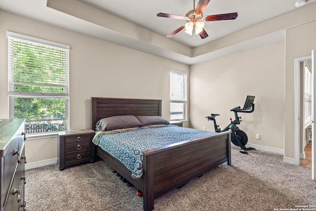 bedroom with light carpet, multiple windows, and ceiling fan