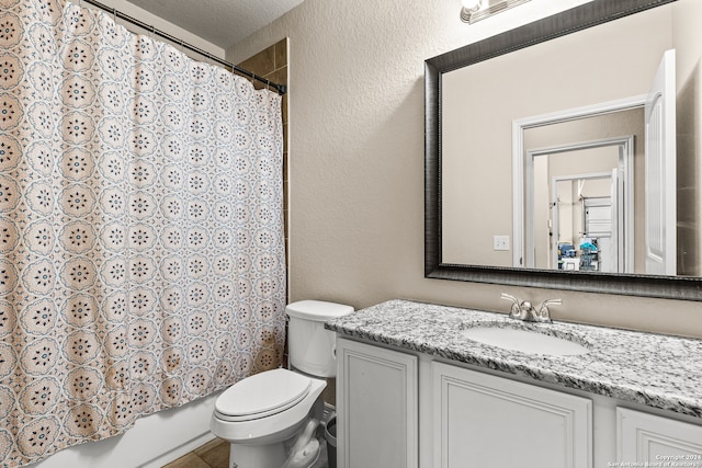 full bathroom featuring vanity, toilet, a textured ceiling, and shower / tub combo