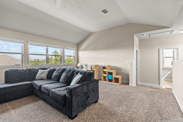 carpeted living room with a wealth of natural light, vaulted ceiling, and ceiling fan