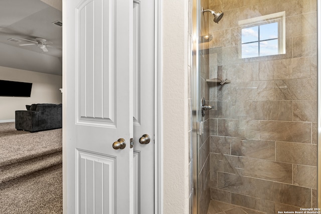 bathroom with ceiling fan and an enclosed shower