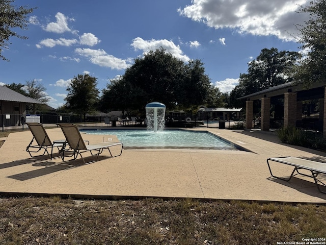 pool with a patio and fence