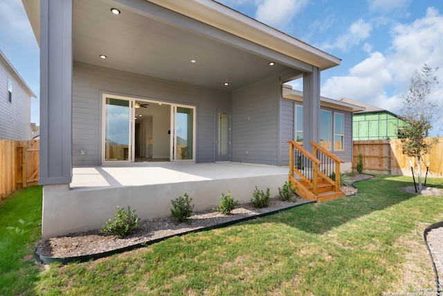 rear view of house featuring a lawn and a patio area