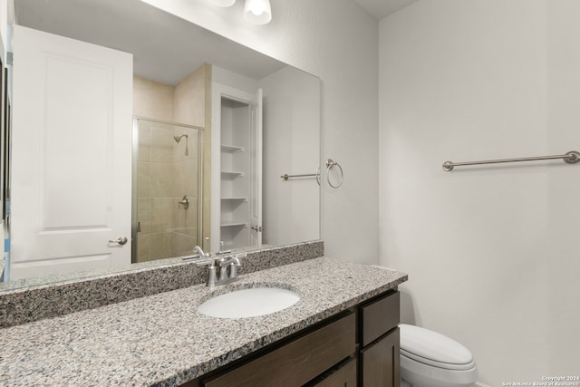 bathroom with vanity, toilet, and an enclosed shower