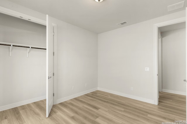 unfurnished bedroom featuring light hardwood / wood-style floors and a closet