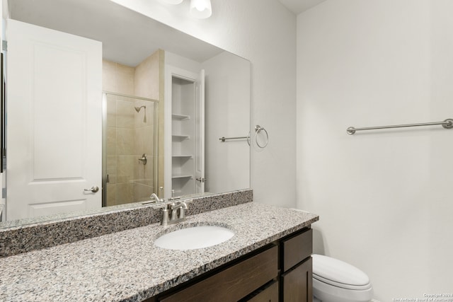 bathroom with walk in shower, vanity, and toilet