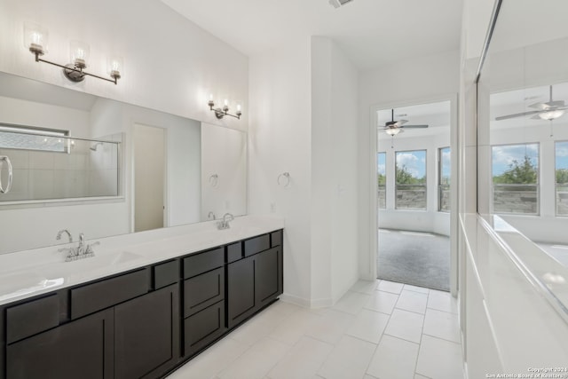 bathroom with ceiling fan, vanity, a tile shower, and tile patterned floors