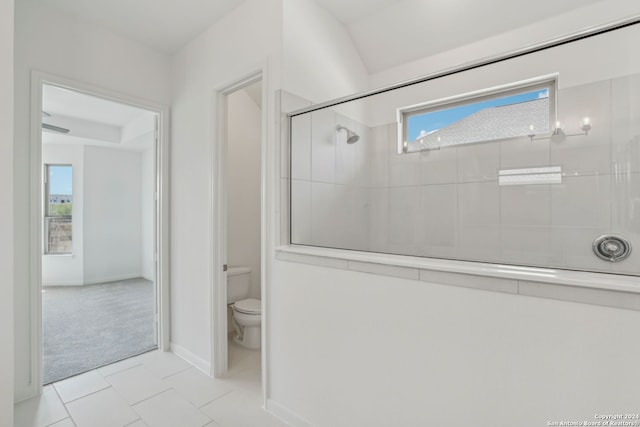 bathroom with toilet, an enclosed shower, and tile patterned floors