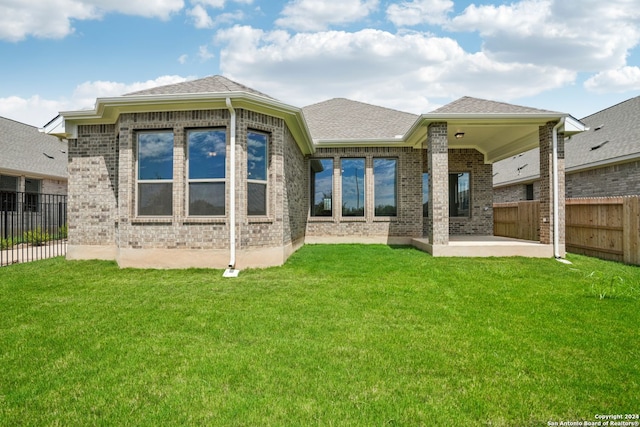 back of property featuring a patio and a yard