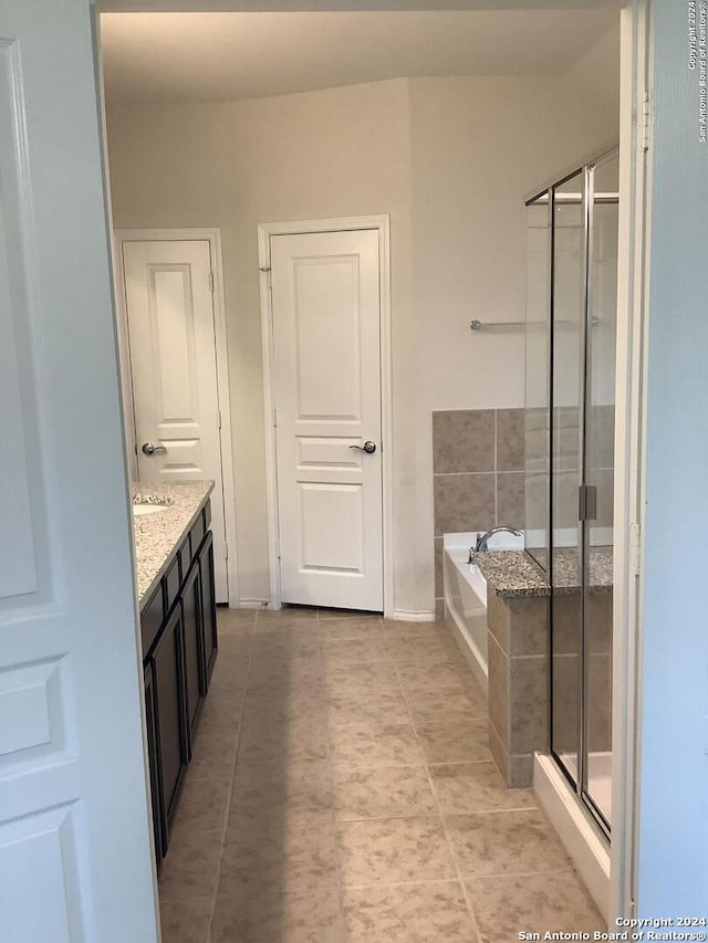 bathroom with vanity, tile floors, and plus walk in shower