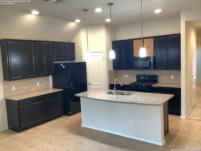 kitchen with light stone counters, light tile flooring, black appliances, an island with sink, and sink