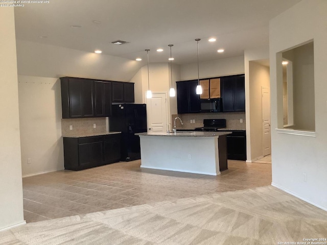 kitchen featuring an island with sink, black appliances, backsplash, and decorative light fixtures