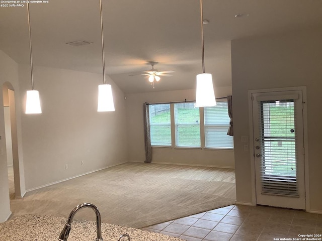 carpeted empty room featuring ceiling fan and lofted ceiling